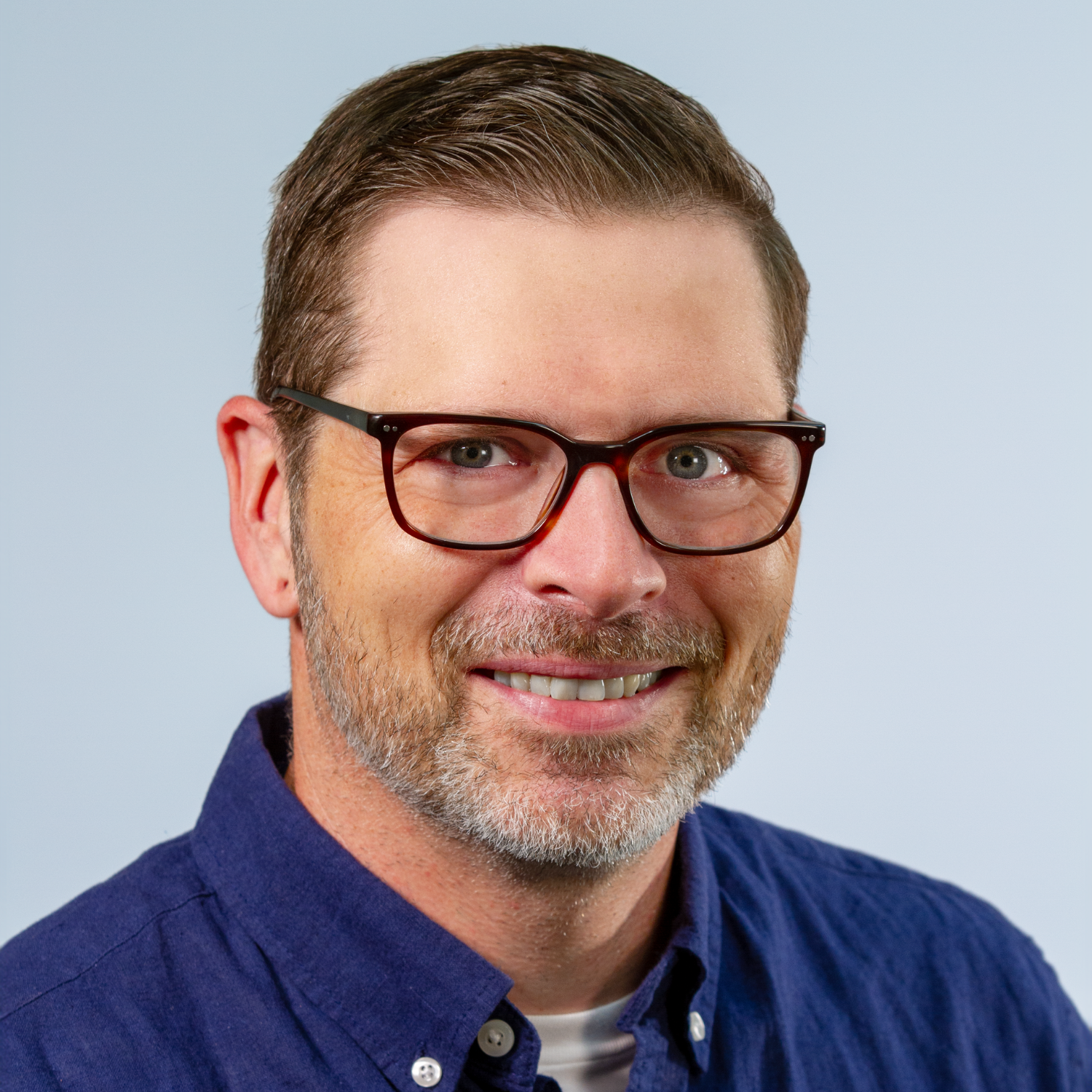 Image: Andrew Coltrin, white male with graying hair and glasses, smiling in his home office.