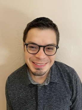 Image: Andrew Coltrin, white male with graying hair and glasses, smiling in his home office.