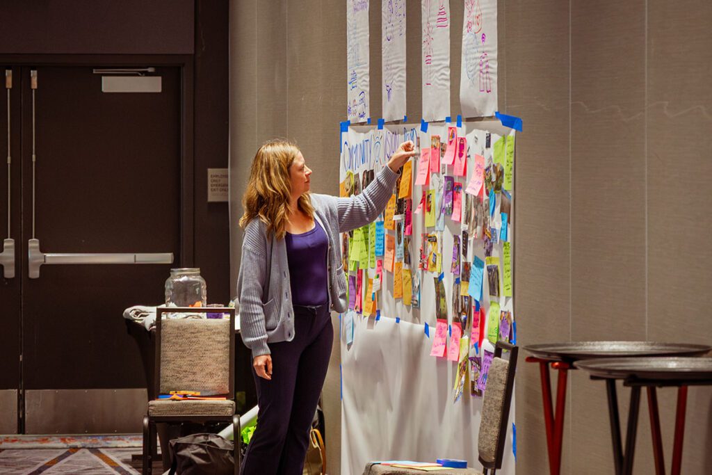 A Wise Training Instructor pinning a note to a large, communal board.