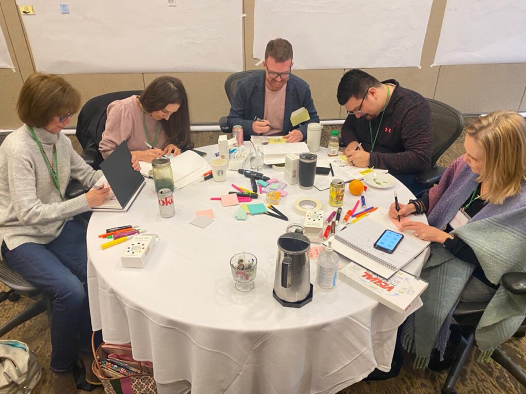 Wise employees practicing and writing as a group on a table.