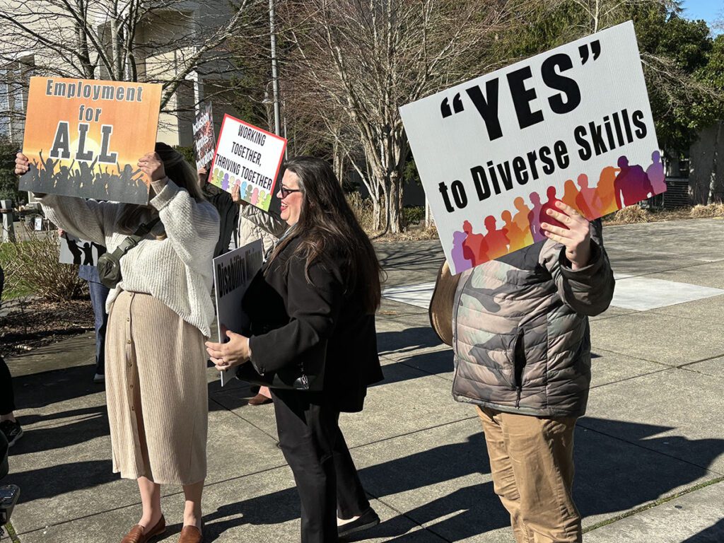 Advocates vying for diversity in the workplace, holding signs for equal employment.