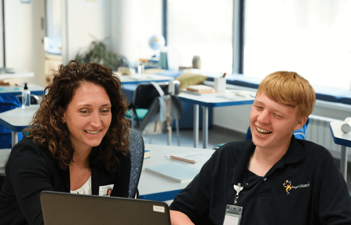 A Wise Staff member working with a happy student.